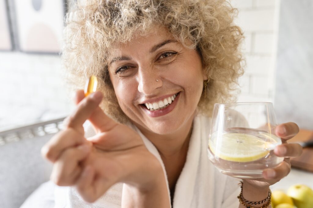 Woman Healthcare. Female Holding Pills and Bottle in a Bright Room